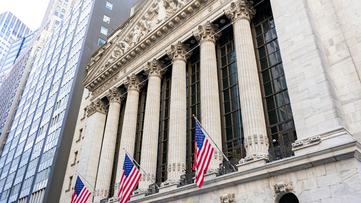 The New York Stock Exchange building with American flags hanging between its columns