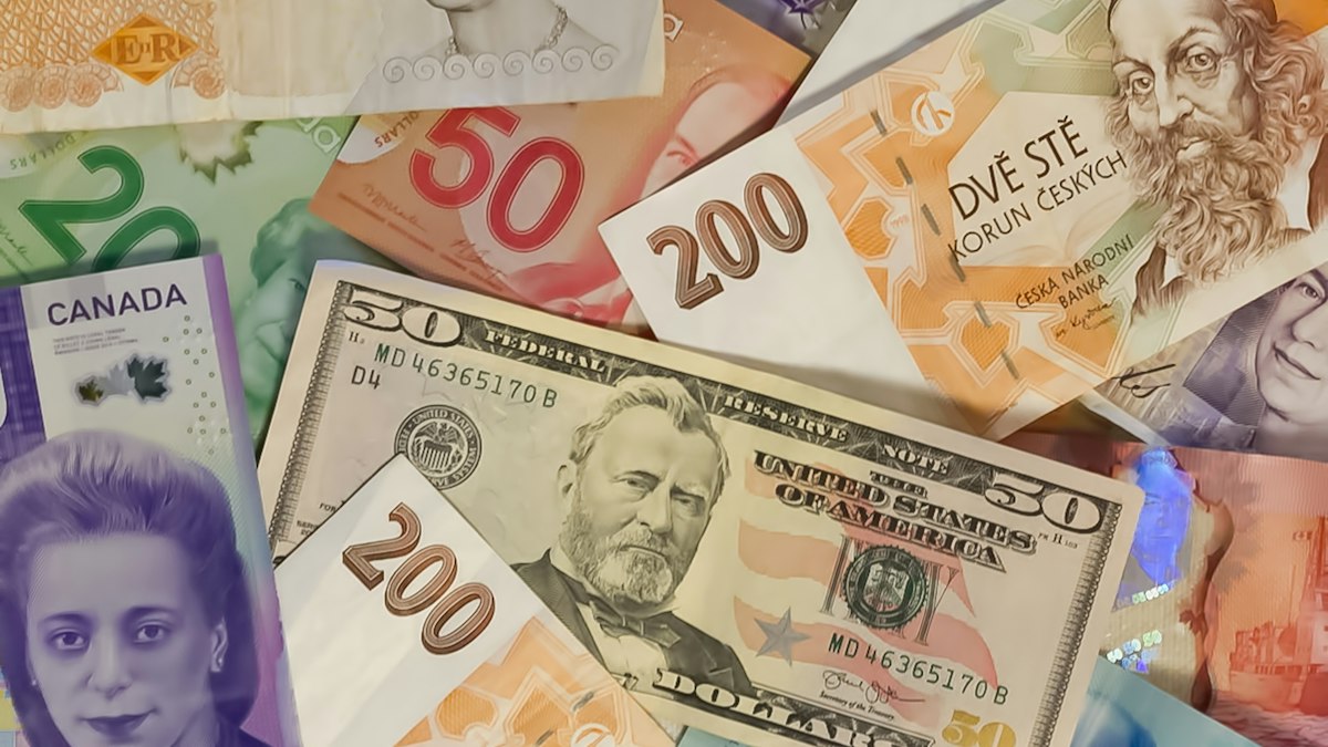 A pile of banknotes from many countries, including US dollars, British pounds, and Canadian bills