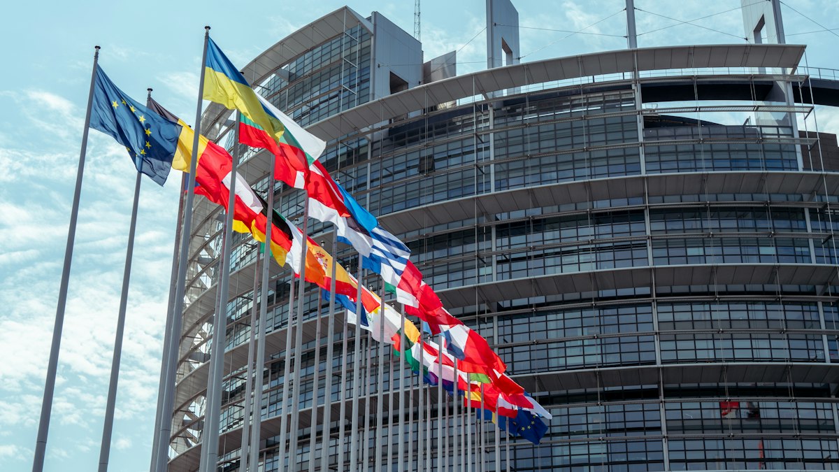 The European Parliament building with a row of national flags in front
