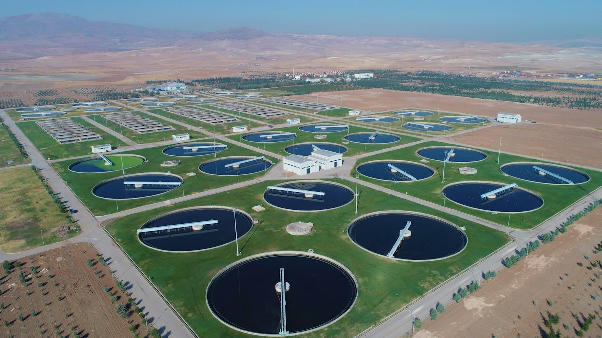 Aerial view of a water treatment plant with rows of circular tanks